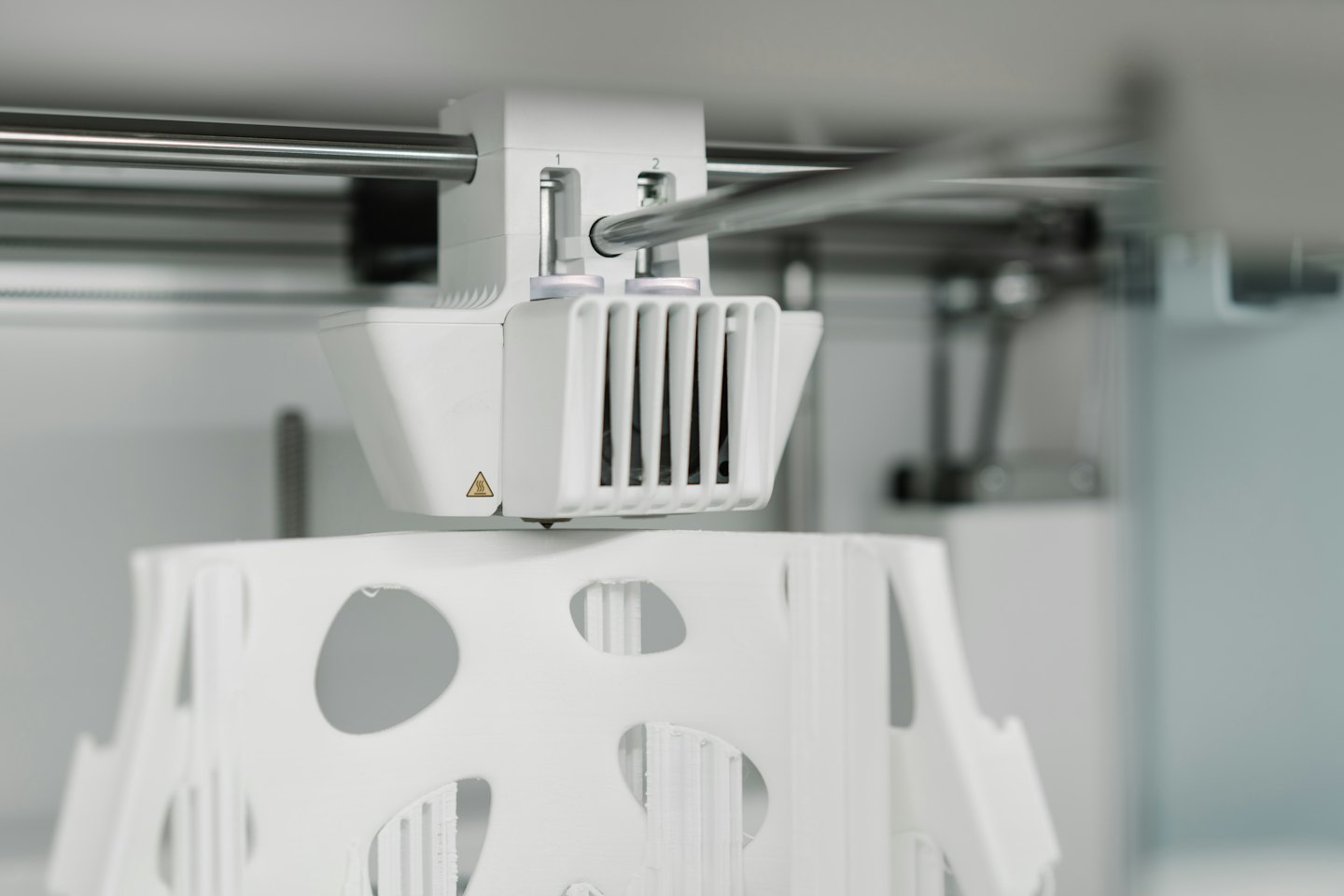 3D-Drucker-Extruder-Kopf fertigt ein weißes abstraktes Objekt.