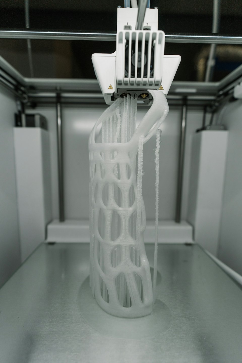 3D-Drucker erstellt ein detailliertes weißes Gitterobjekt.